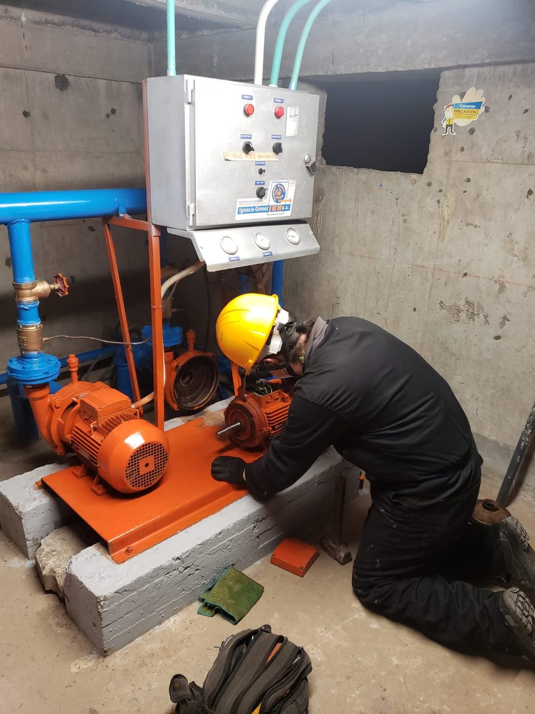 Técnico de Servihidráulicos SAS reparando el motor de una electrobomba en un cuarto de bombas en Bogotá