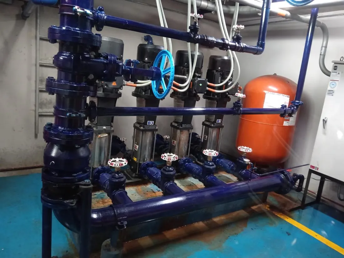 Equipo de presión de agua potable con bombas verticales multietapa y tanque hidroneumático en un edificio de Bogotá