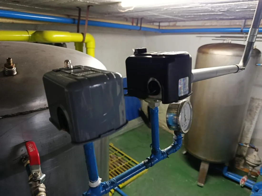 Presostatos y manómetro de un equipo de presión de agua potable en mantenimiento en Bogotá